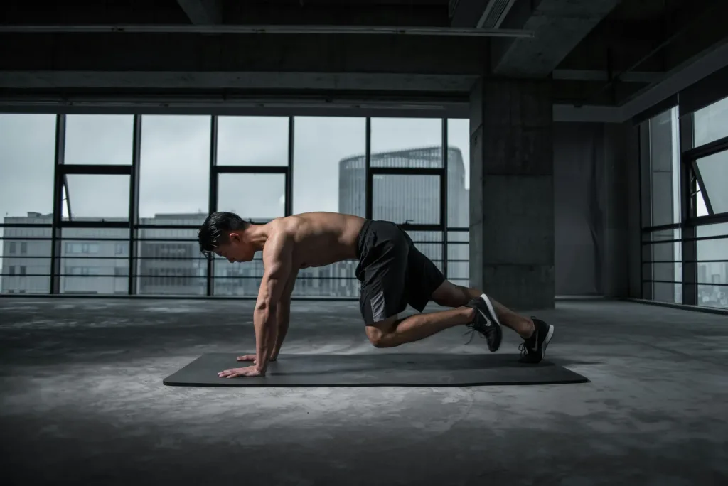 plan de entrenamiento para principiantes - Hombre haciendo escaladores sobre un tapete