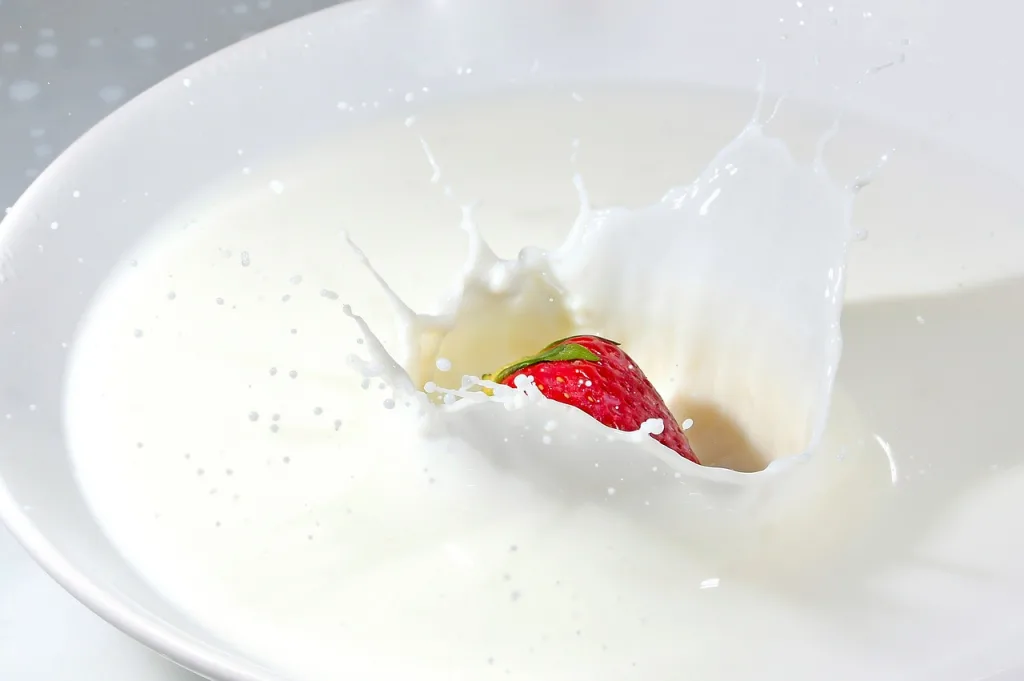fresa cayendo sobre un plato de leche