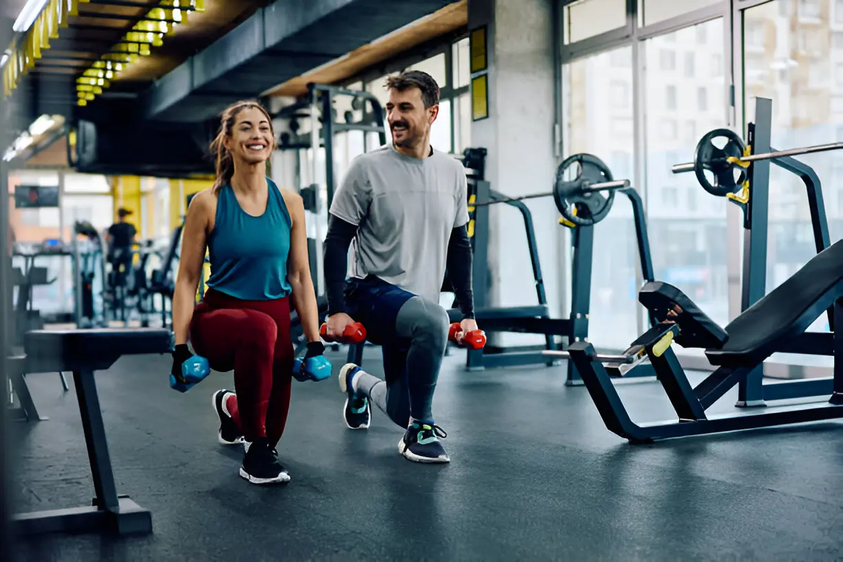 somatotipo - un hombre y una mujer haciendo lunges con mancuerna en el gimnasio